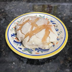 A type of bread, called concha, placed on a small plate.