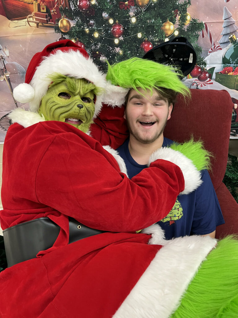 Grinch @ holiday outreach event for foster families, along with Grinch's son volunteering to help at the event.