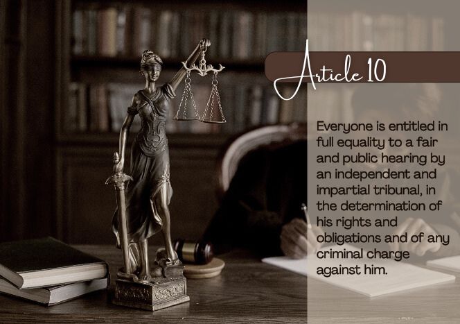 Statue of Lady Justice holding scales on a desk in a judge's chambers as she sits working on papers, with law books and a gavel in the background. Image displays Article 10 of the Universal Declaration of Human Rights: "Everyone is entitled in full equality to a fair and public hearing by an independent and impartial tribunal, in the determination of his rights and obligations and of any criminal charge against him."